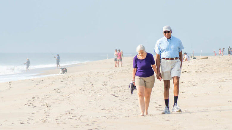 old couple walking on the beach