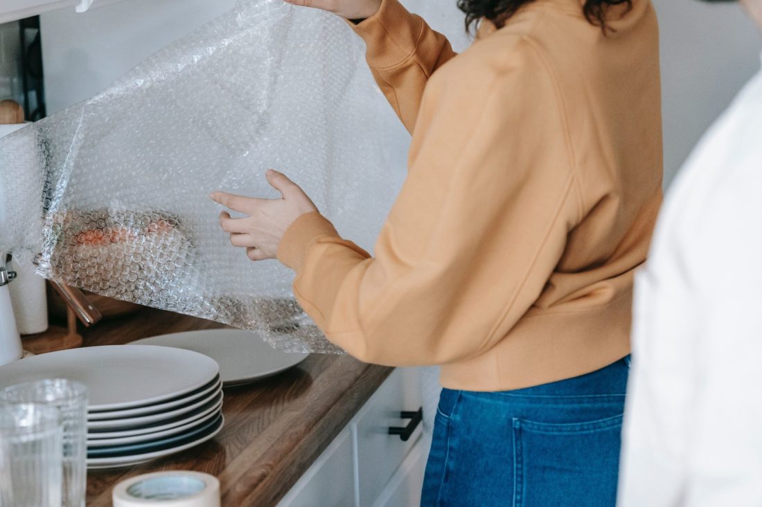 girl is wrapping plates using bubble wrap