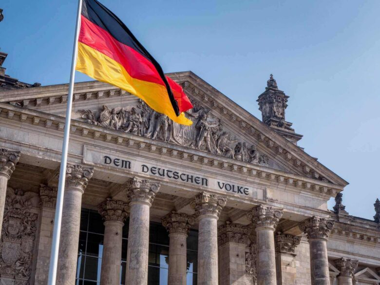 A German flag in front of a parliament building