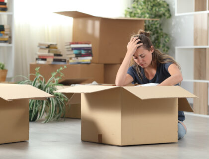 A sad woman sitting on the floor with a box