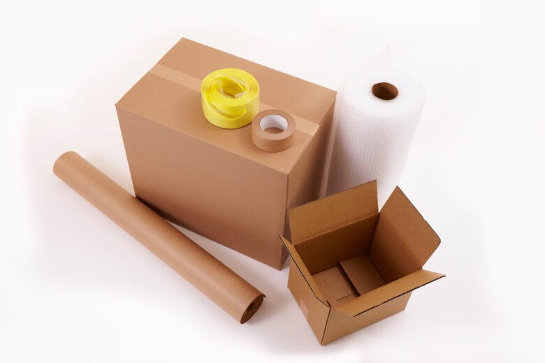 Packing materials - Boxes, tape, a roll of bubble wrap, and a roll of packing paper