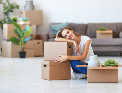 A smiling girl sitting with packed boxes