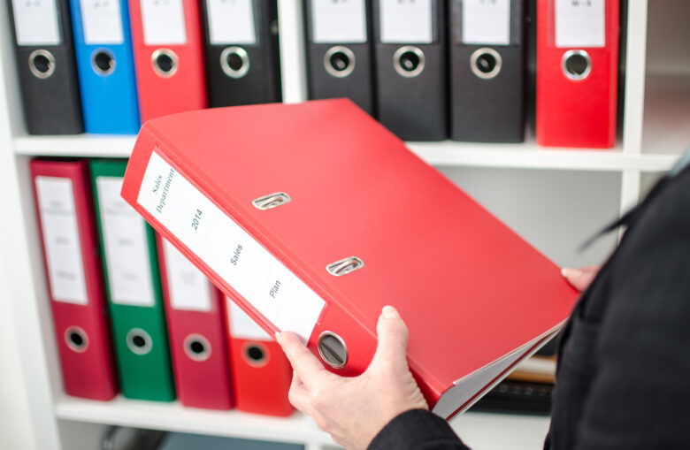 Person holding a red folder